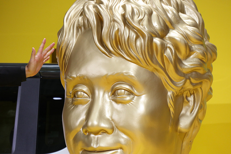 司会者から感想を求められた大泉さんは「素晴らしいじゃないですか！　すごい再現度ですよ。果たしてこの目尻のシワまで再現する必要があったのか、という。若干の老け感まで再現しちゃってる」とコメント。大泉さんが協力したのは十数分の撮影のみとのことだが、本人も驚くほど細部まで作り込まれており、「やはり目の下のくま（が自分の顔の特徴）でしょうね。あとこのウェービーヘア、この重たいまぶた、だらしない口もと、低い鼻ってやかましいな」と口にして会場を笑わせた